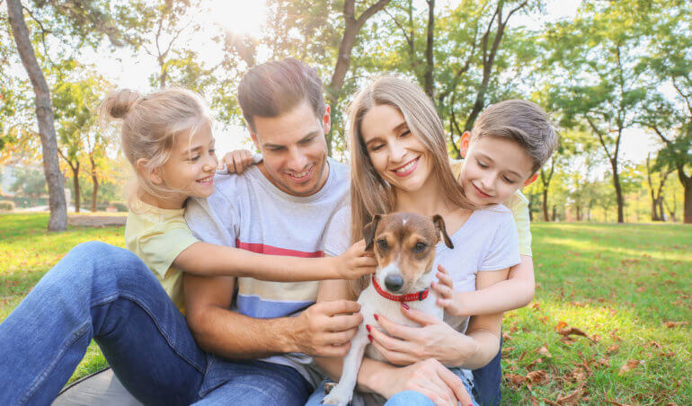 mãe, pai e filhos com um cachorrinho, que pode ser incluído no espaço pet em condomínios