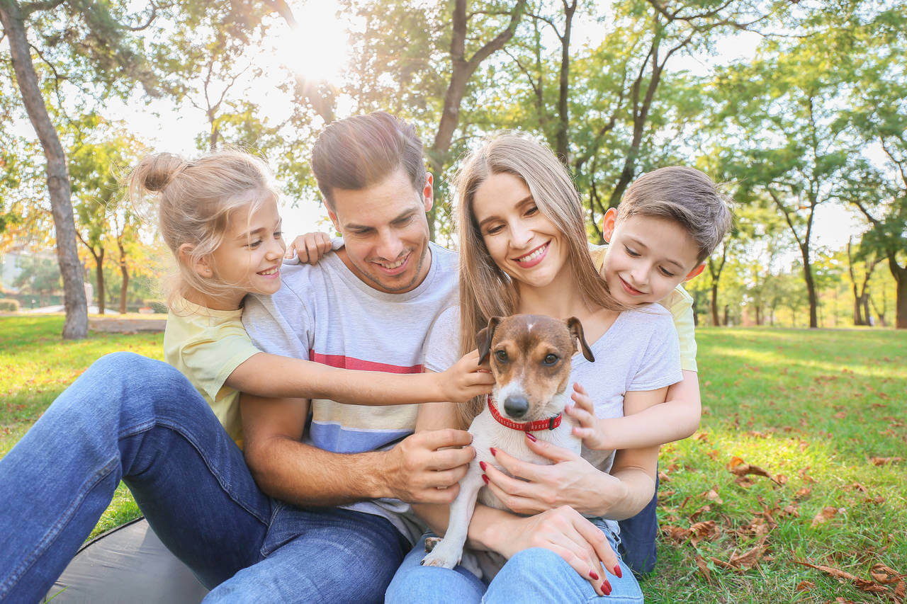 mãe, pai e filhos com um cachorrinho, que pode ser incluído no espaço pet em condomínios