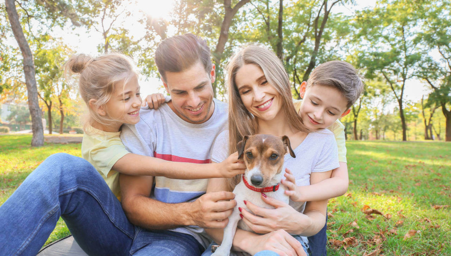 mãe, pai e filhos com um cachorrinho, que pode ser incluído no espaço pet em condomínios